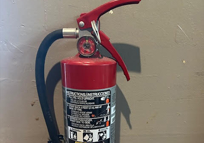 Fire inspector examining fire extinguisher during commercial property inspection.