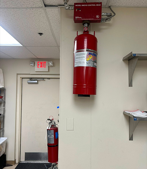 Fire extinguisher on wall in commercial building, Freedom Fire Inspectors service.